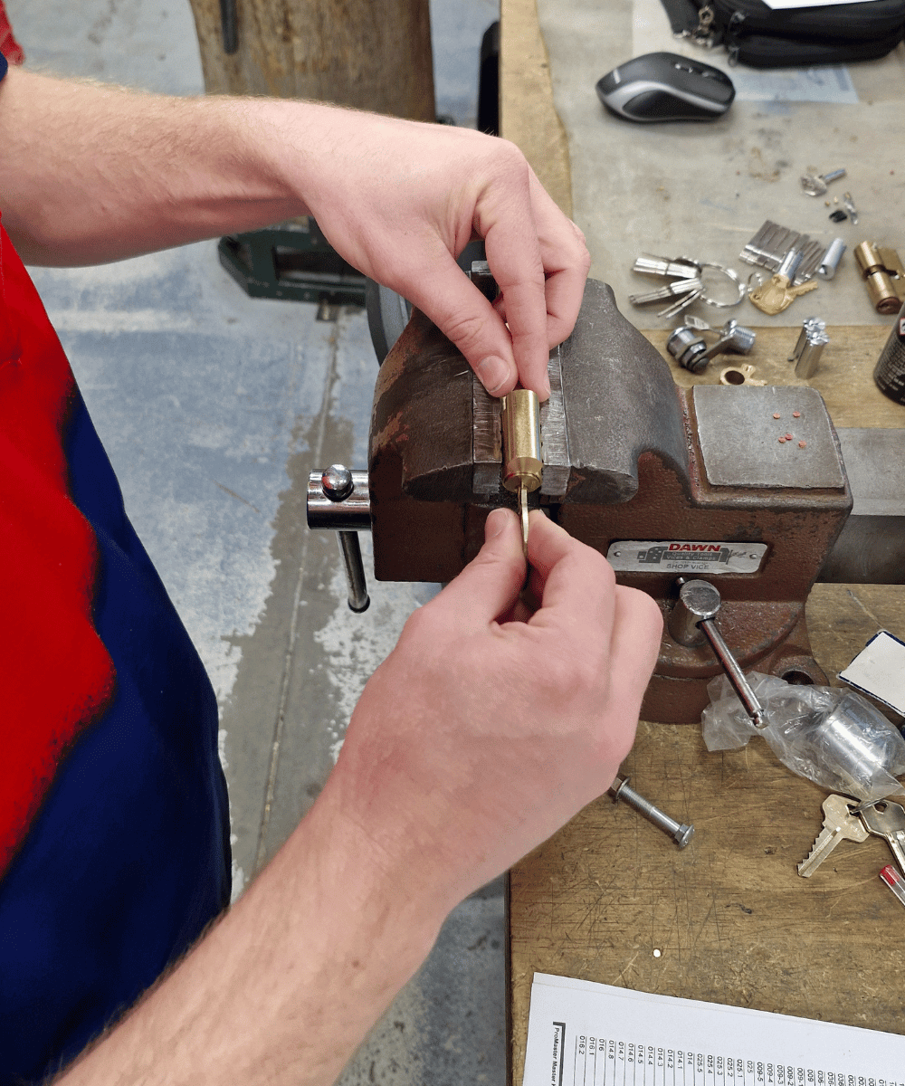 Morayfield Locksmiths technician removing a lock barrel in the workshop to rekey it providing locksmith services in Moreton Bay